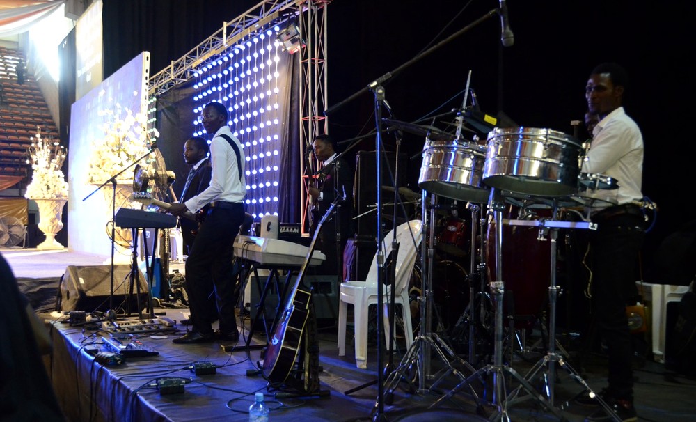 Live band on stage — keys, guitar and steel drums